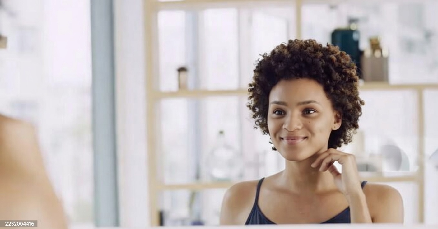 mulher praticando amor próprio se olhando no espelho com calma e serenidade