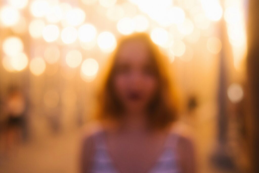 Pessoa em ambiente social com olhar vago e expressão ausente representando o piloto automático da dissociação emocional cotidiana