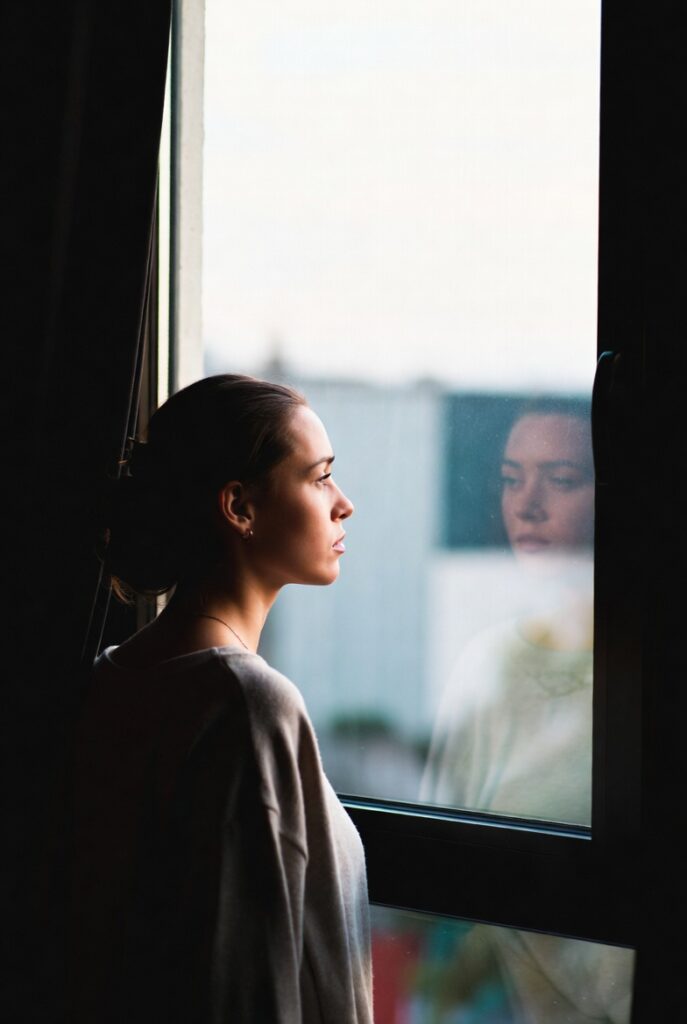 pessoa olhando pela janela refletindo sobre falta de motivação e desalinhamento