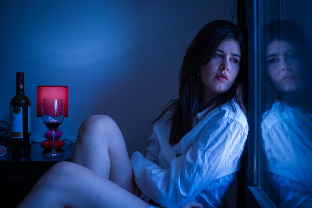 Mulher em momento de reflexão profunda olhando para si mesma, representando a perda gradual de identidade num relacionamento tóxico