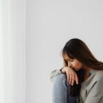 Mulher sozinha com expressão de peso interior e olhar distante representando o sofrimento silencioso de um relacionamento que faz mal