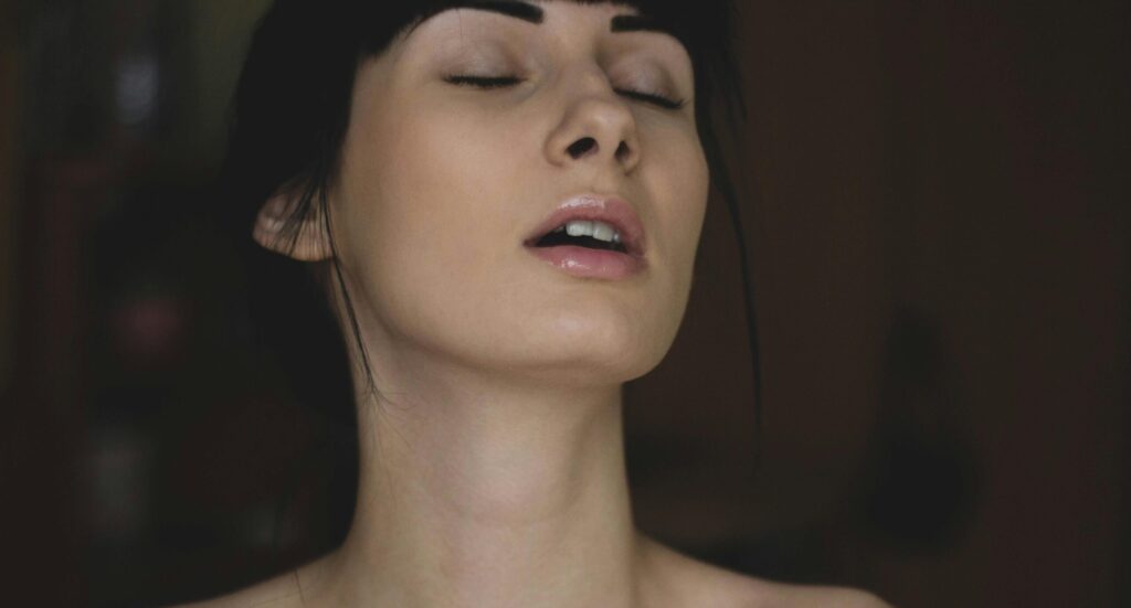 Mulher sensível sentada sozinha olhando pela janela em momento de introspecção