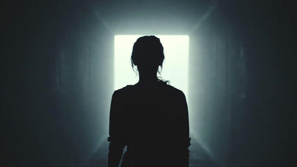 Mulher caminhando em direção à luz representando o momento de reconhecer o chamado interior que a alma esta pedindo uma mudança